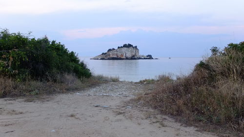 Scenic view of beach against cloudy sky