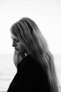 Close-up of young woman against white background