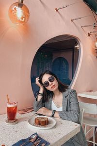 Portrait of young woman sitting in sunglasses