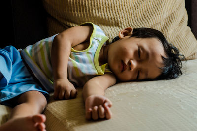 Cute boy lying on bed at home