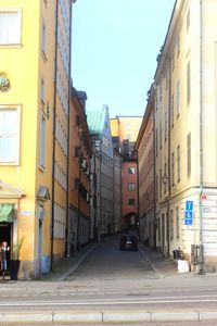 Cars on street in city against clear sky