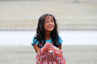 Portrait of smiling girl in rain