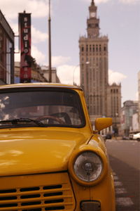 Close-up of yellow taxi parked on city street