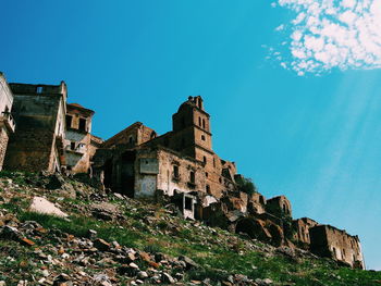 Low angle view of old building against blue sky