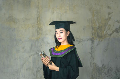 Portrait of beautiful woman standing against wall