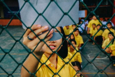 Portrait of man seen through chainlink fence