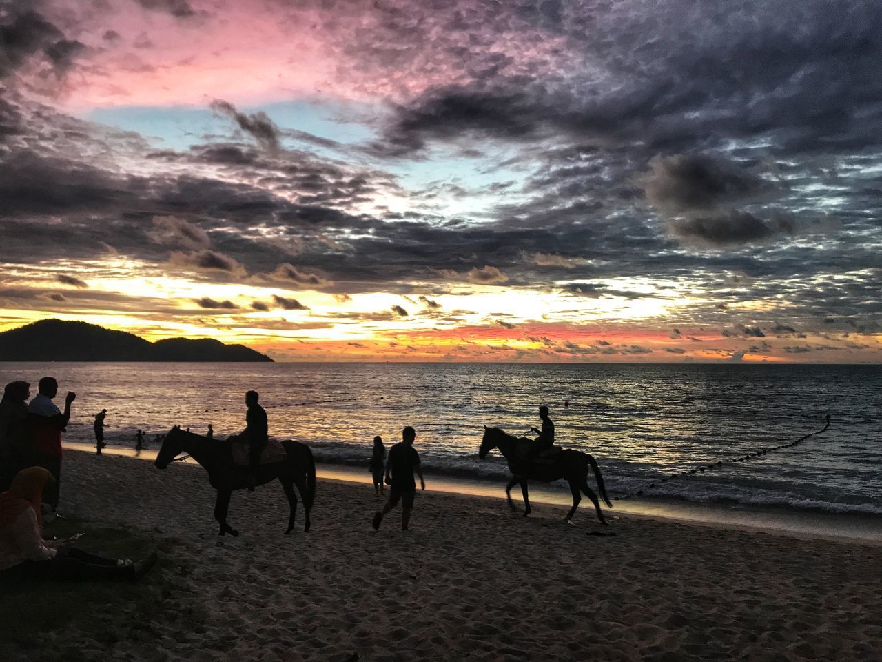 PEOPLE ON BEACH AGAINST SKY DURING SUNSET