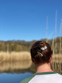 Rear view of woman against lake reflections