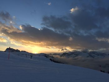 Scenic view of snow covered mountains against sky during sunset