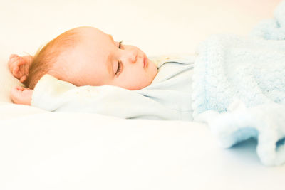 Close-up of baby sleeping on bed