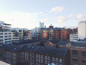 Buildings against cloudy sky