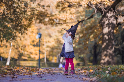 Little girl in halloween forest. child playing in autumn park. 