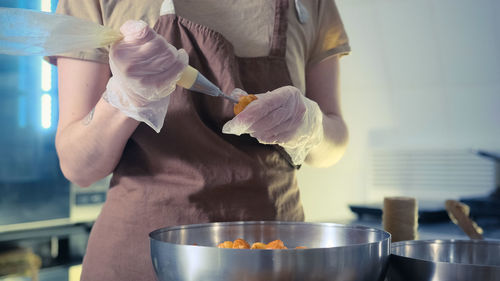 Midsection of woman preparing food at home