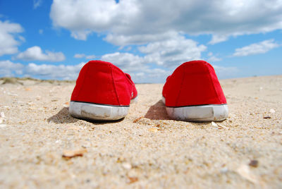 Red umbrella on beach against sky