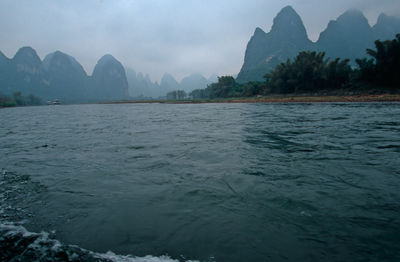 Scenic view of sea and mountains against sky