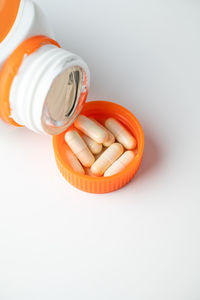 High angle view of orange bottle on white background