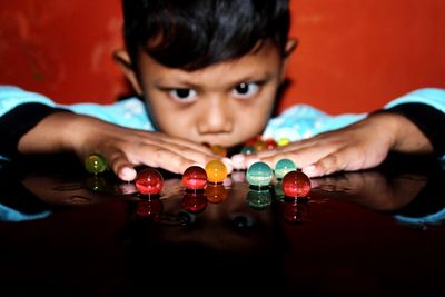 Close-up of boy looking at marbles on table