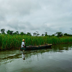 Rear view of man in lake against sky