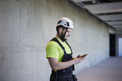 Worker using cell phone at building site