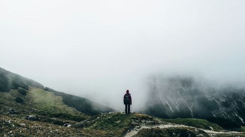 Rear view of woman standing on mountain landscape