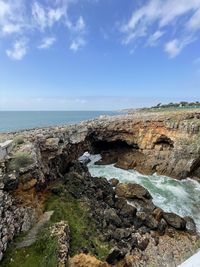 Rocks by sea against sky