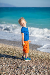 Full length portrait of boy standing at beach