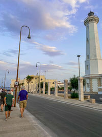 Rear view of woman walking on street against buildings