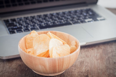 Close-up of wafers in bowl against laptop on table