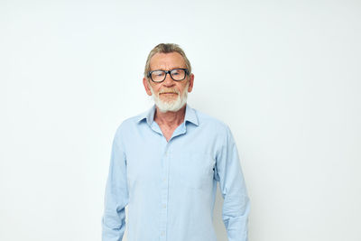 Portrait of young man standing against white background