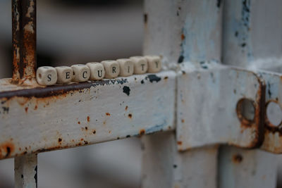 Close-up of wooden blocks on rusty metal gate
