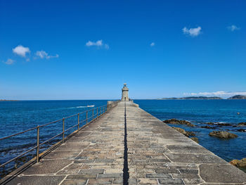 Pier over sea against blue sky