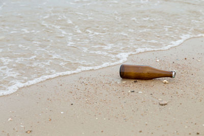 Close-up of cigarette bottle on beach