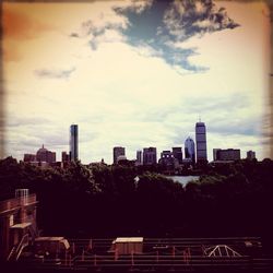 View of cityscape against cloudy sky