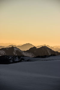 Scenic view of mountains against clear sky during sunset