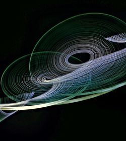 Close-up of spiral illuminated against black background