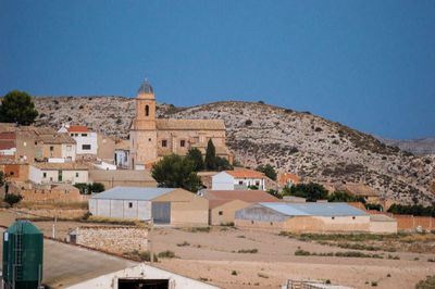 Buildings in city against clear blue sky