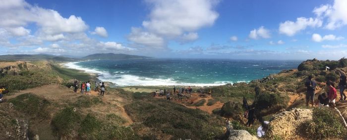 Panoramic view of people on beach against sky