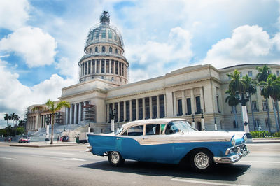 Vintage car on road against buildings in city