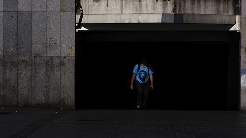 Full length of man standing on footpath against building