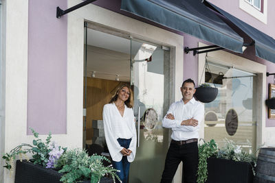 Smiling business colleagues standing at entrance of restaurant