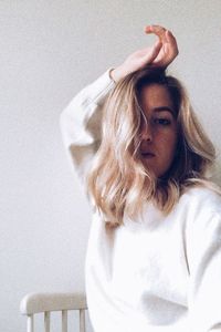Portrait of woman against white wall