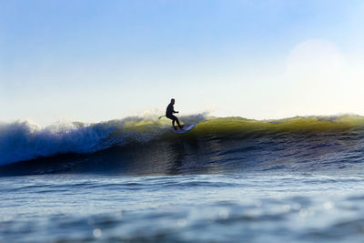 Man surfing in sea against clear sky