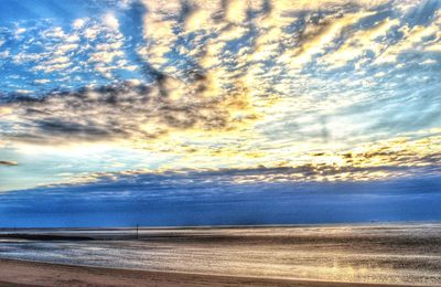 Scenic view of sea against cloudy sky