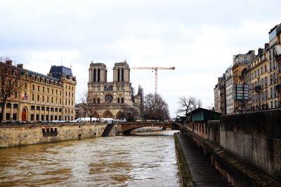 Bridge over river against buildings in city