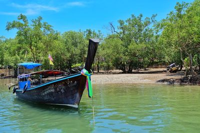 Boat moored in river against sky