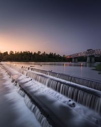 Scenic view of river against clear sky during sunset