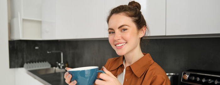 Young woman using mobile phone at home