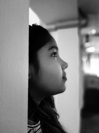 Portrait of young woman looking away at home