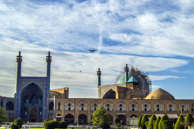 Buildings in city against cloudy sky