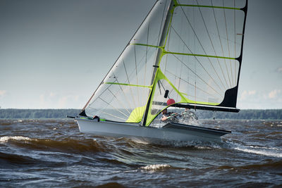 Sailboat sailing on sea against sky